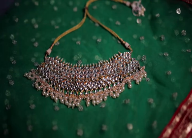 A slow motion shot of elegant Indian bridal jewelry featuring an ornate necklace, bangles, earrings, and headpiece
