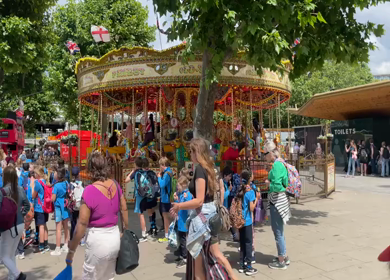 19th June 2024 : Children riding colorful carousel in London England