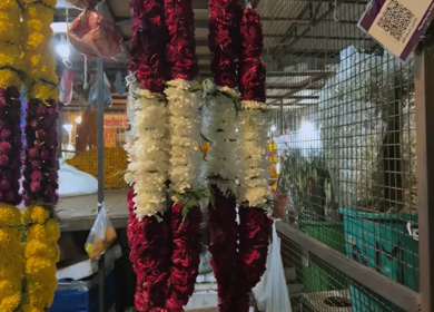 A Slow Motion shot of Colorful Flower Garlands Hanging at Market Shop in Delhi India