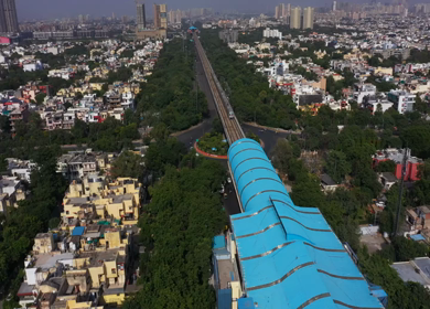 An aerial shot of the Delhi metro arriving at the station in New Delhi, India