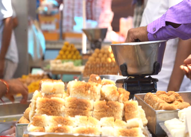 A close up shot of people buying sweets at New Delhi, India