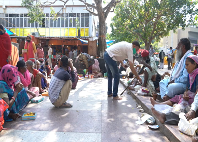 A static shot people distributing prasad to beggars outside Hanuman Mandir