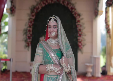Indian Bride Posing for Wedding Photoshoot Wearing Traditional Bridal Attire and Jewelry at her wedding