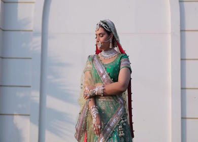 Indian Bride Posing for Wedding Photoshoot Wearing Traditional Bridal Attire and Jewelry at her wedding