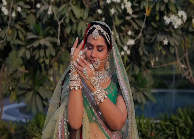 Indian Bride Posing for Wedding Photoshoot Wearing Traditional Bridal Attire and Jewelry at her wedding