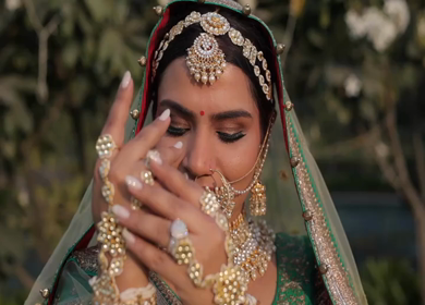Indian Bride Posing for Wedding Photoshoot Wearing Traditional Bridal Attire and Jewelry at her wedding