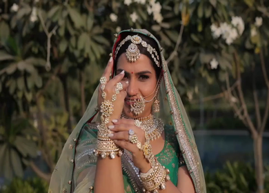 Indian Bride Posing for Wedding Photoshoot Wearing Traditional Bridal Attire and Jewelry at her wedding