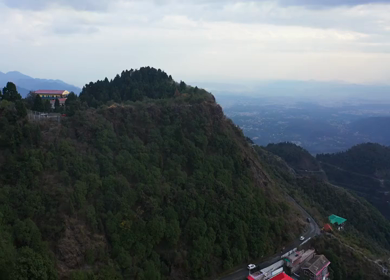 An aerial shot of Queen of the Hills which is Mussorrie being surrounded by Greenery and Blue Sky