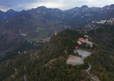 An aerial shot of Queen of the Hills which is Mussorrie being surrounded by Greenery and Blue Sky