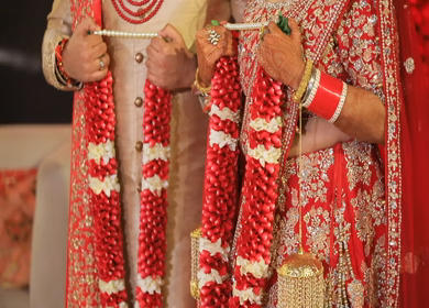 New Delhi,NCR,India-9th February,2019: Tilt up shot of an Indian couple posing towards camera while holding their jai mala at their Indian wedding in New Delhi,India