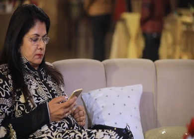 New Delhi,NCR,India-9th February,2019: A Pan left shot of an Indian lady burping and surfing on her phone at an Indian wedding in New Delhi,India