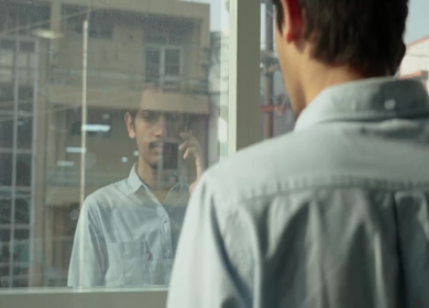 A Shot of an Indian Boy doing work discussion over a phone call in office