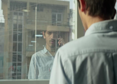 A Shot of an Indian Boy doing work discussion over a phone call in office