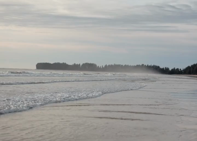 Slow motion shot of gentle ocean waves rolling onto the beach in Phuket, Thailand