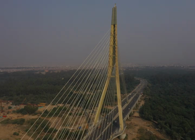 An aerial shot of the Signature Bridge with cars moving in New Delhi, India