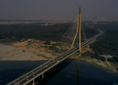An aerial hyperlapse shot of the Signature Bridge with cars moving in New Delhi, India