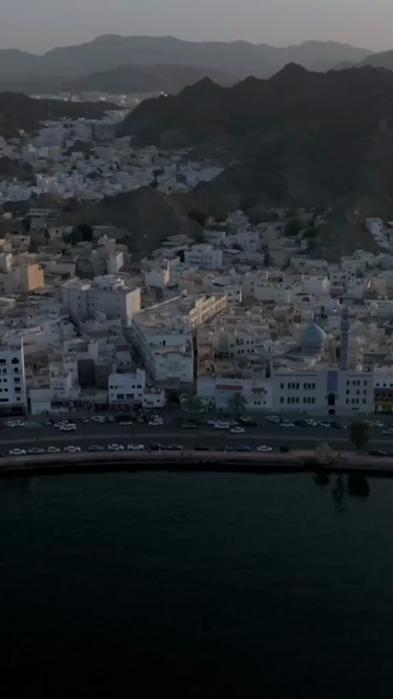 Vertical Aerial Evening View of Mutrah Corniche Muscat Oman with Hajar Mountains
