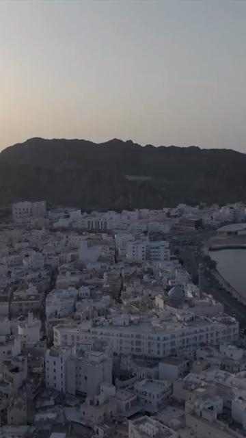 Vertical Aerial Evening View of Mutrah Corniche Muscat Oman with Hajar Mountains