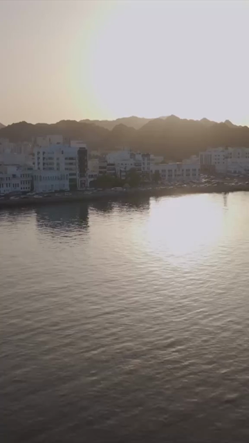 Vertical Aerial Evening View of Mutrah Corniche Muscat Oman with Hajar Mountains