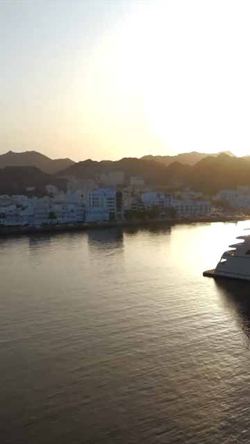 Vertical Aerial Evening View of Mutrah Corniche Muscat Oman with Hajar Mountains