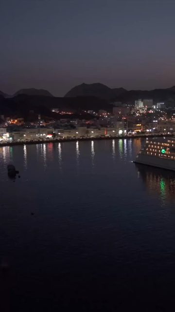 Vertical Aerial Night View of Mutrah Corniche Muscat Oman Waterfront and City Lights