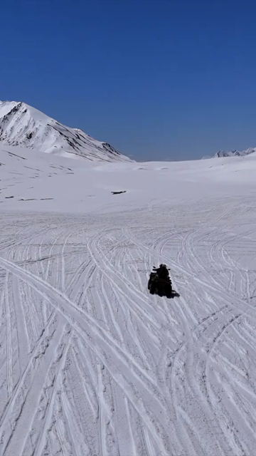 Vertical Aerial View of ATV Riding Across Snow Covered Landscape in Ladakh India