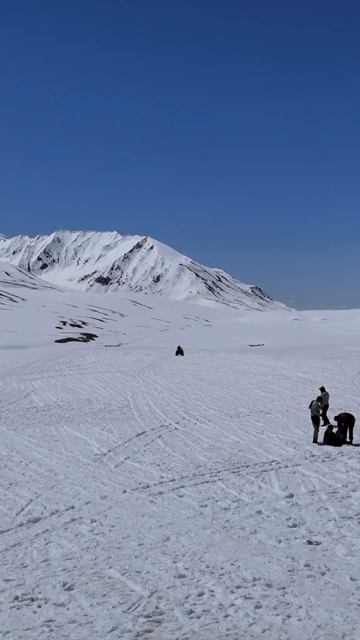 Vertical Aerial View of ATV Riding Across Snow Covered Landscape in Ladakh India
