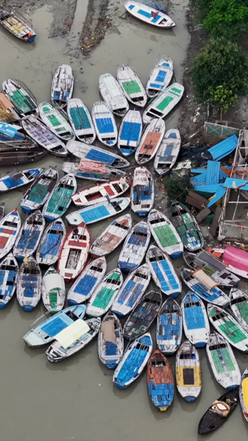 Vertical Aerial View of Boats Gathered Along Riverbank in Prayagraj Uttar Pradesh India