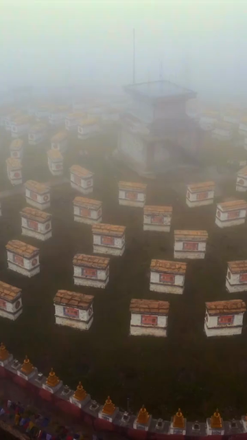 Vertical Aerial View of Mandala Top Buddhist Stupas Covered in Fog in Arunachal Pradesh India