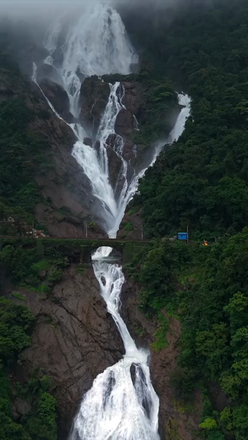 Vertical Aerial View of Dudhsagar Waterfall Surrounded by Lush Forest in Goa India