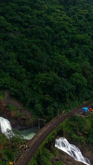 Vertical Aerial View of Dudhsagar Waterfall Surrounded by Lush Forest in Goa India
