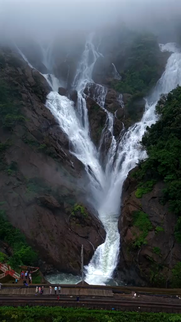 Vertical Aerial View of Dudhsagar Waterfall Surrounded by Lush Forest in Goa India