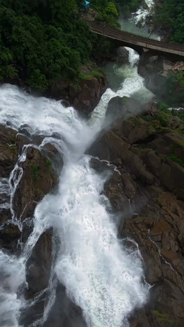 Vertical Aerial View of Dudhsagar Waterfall Surrounded by Lush Forest in Goa India