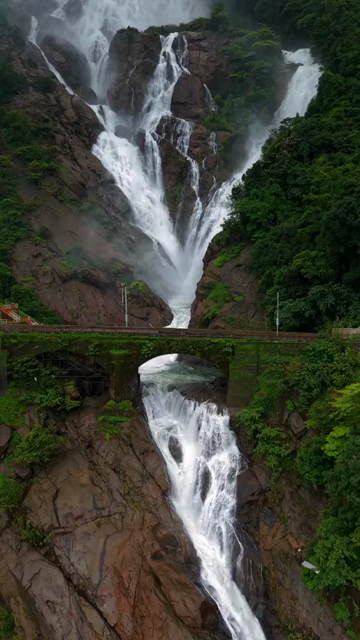 Vertical Aerial View of Dudhsagar Waterfall Surrounded by Lush Forest in Goa India