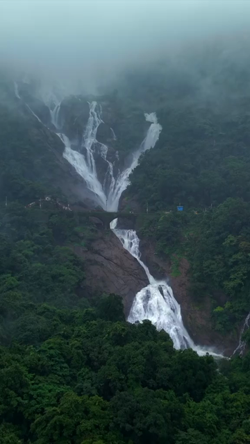 Vertical Aerial View of Dudhsagar Waterfall Surrounded by Lush Forest in Goa India