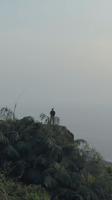 Vertical Aerial View of Man Standing on Cliff at Apsarakonda Coast Karnataka India