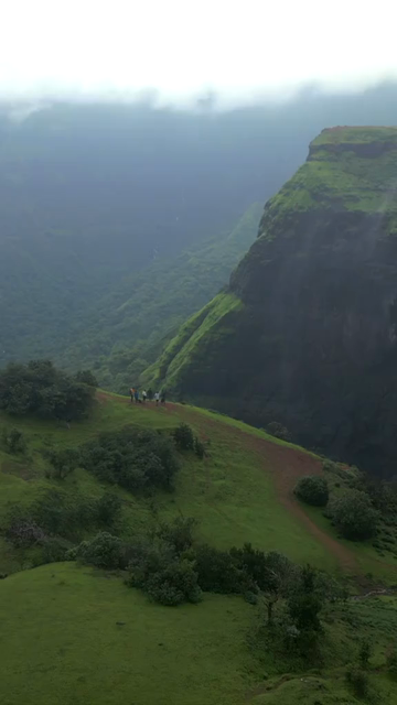 Vertical Aerial View of Misty Mountain Cliffs and Lush Green Landscapes in Maharashtra