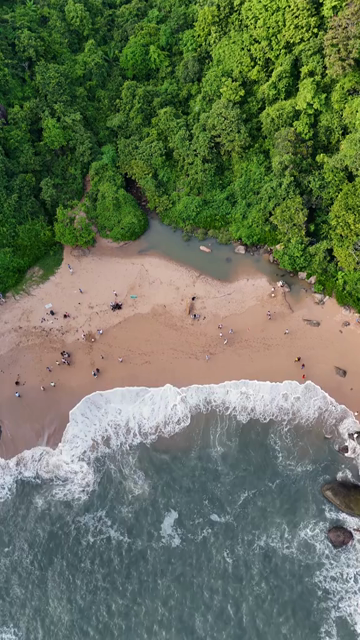 Vertical Aerial View of Tropical Beach and Rocky Coastline in Goa India