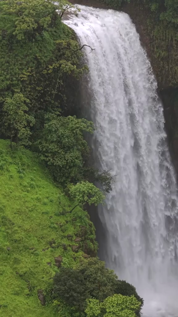 Vertical Aerial View of Waterfall in Misty Green Hills of Maharashtra