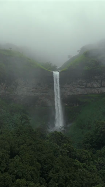Vertical Aerial View of Waterfall in Misty Green Hills of Maharashtra
