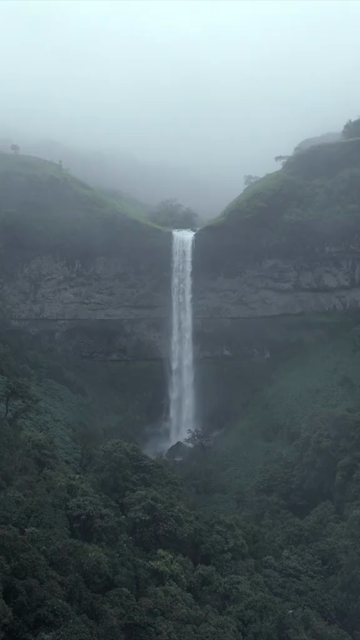 Vertical Aerial View of Waterfall in Misty Green Hills of Maharashtra