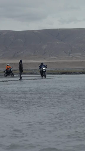 Vertical Shot of Adventure Motorcyclist Crossing River in Ladakh, India
