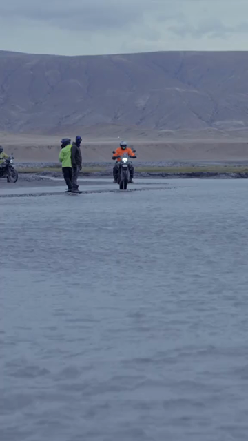 Vertical Shot of Adventure Motorcyclist Crossing River in Ladakh, India