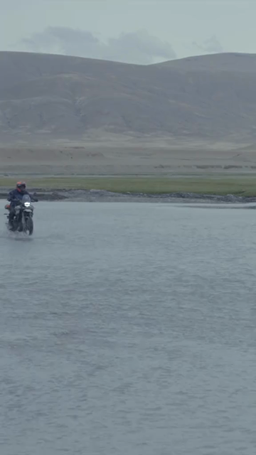 Vertical Shot of Adventure Motorcyclist Crossing River in Ladakh, India