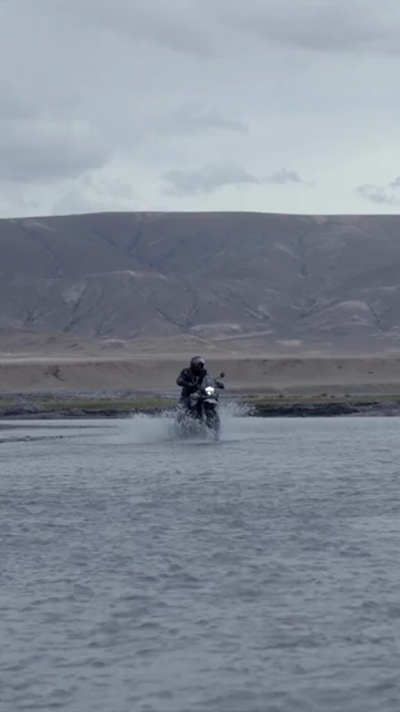 Vertical Shot of Adventure Motorcyclist Crossing River in Ladakh, India