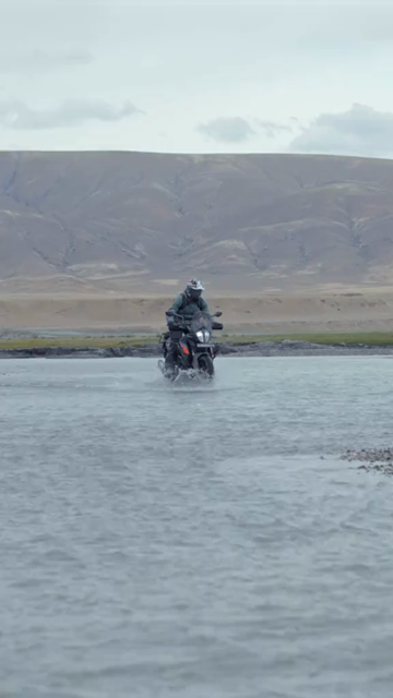 Vertical Shot of Adventure Motorcyclist Crossing River in Ladakh, India