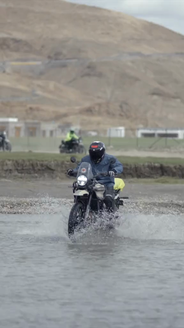 Vertical Shot of Adventure Motorcyclist Crossing River in Ladakh, India
