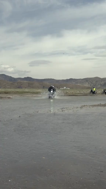 Vertical Shot of Adventure Motorcyclist Crossing River in Ladakh, India