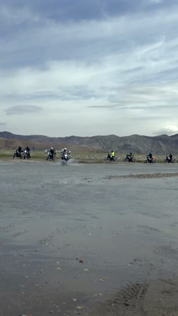 Vertical Shot of Adventure Motorcyclist Crossing River in Ladakh, India
