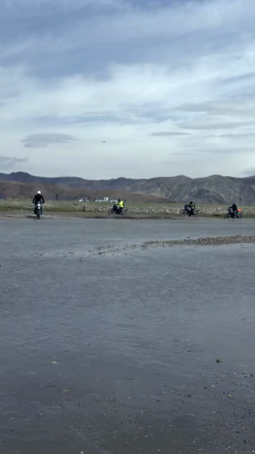 Vertical Shot of Adventure Motorcyclist Crossing River in Ladakh, India